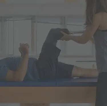 En sjukgymnast behandlar en persons ben