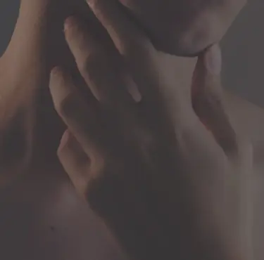 Personen med Graves sjukdom håller en hand vid halsen.